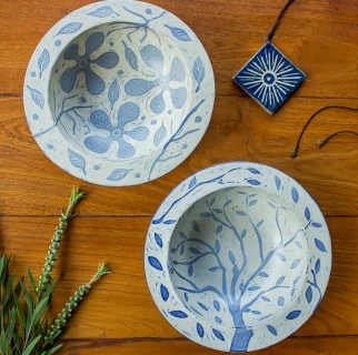 two blue and white carved bowls with floral designs